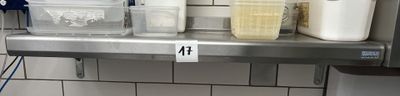 une étagère en métal sur laquelle sont posés des récipients en plastique, dans une cuisine