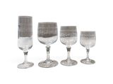 six verres à vin sont alignés sur une surface blanche