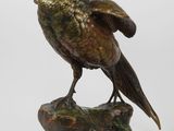 une image représentant une statue en bronze d'un oiseau posé sur un rocher