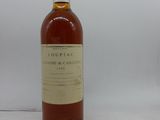 La bouteille d'alcool est posée sur la table près du mur.