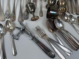 a lot of silver spoons and forks on the table