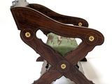 a wooden chair that has a green cushion on it