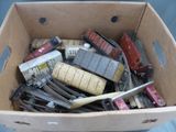 une boîte en carton remplie de rails de train miniature et d'autres petits trains