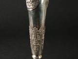 un vase en argent orné d'un lion sur fond noir