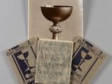 an old photo of a book and a cup on top of a table