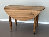 une petite table avec un plateau en bois, montée sur roulettes