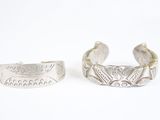 une paire de bracelets manchette en argent sur fond blanc