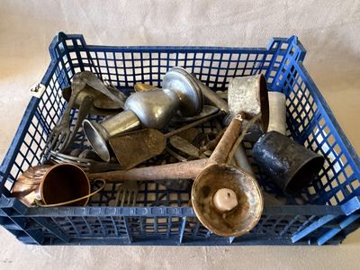 un panier rempli de vieux ustensiles de cuisine posé sur une table