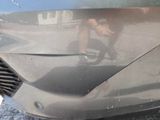 a close up of the front of a car with a denting on it