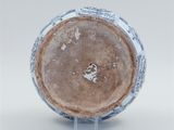 a blue and white vase sitting on a clear stand