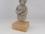 statue d'un homme aux bras croisés, posée sur un socle en bois