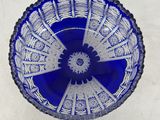 a blue glass bowl sitting on a white surface