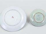 a white plate and a green plate on a white table