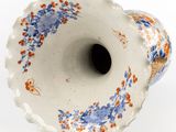 a white vase with blue and orange flowers on it