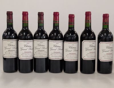 six bottles of red wine lined up in a row on a table