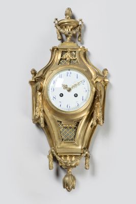 a gold clock hanging on the wall on the wall