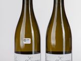 deux bouteilles de vin posées l'une à côté de l'autre sur une surface blanche