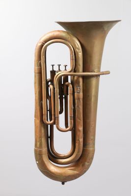 an image of a brass tuba on a stand against a white background