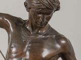 bronze statue of a man holding a bow and arrow