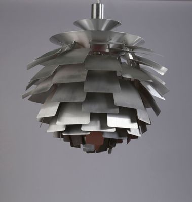 a metal light hanging from the ceiling in a room