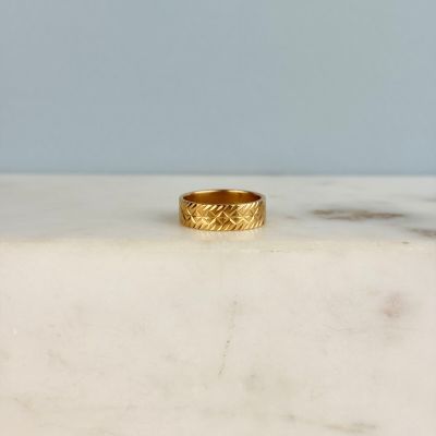 an image of a gold ring on a marble surface