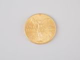 a gold coin on a white surface with a white background