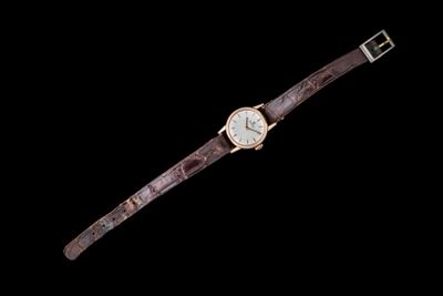 gros plan d'une montre sur une surface noire avec un fond noir