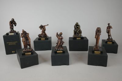 six figurines de soldats en bronze posées sur des socles, sur une surface blanche