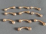 six paires de piercings chirurgicaux plaqués or sur un fond gris