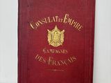 un vieux livre rouge orné de lettres dorées, posé sur une surface blanche