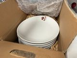 a cardboard box filled with plates and bowls in it