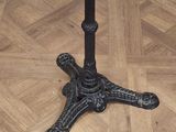 a white marble table with a black base on a parquet floor