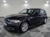 une photo d'une voiture bmw noire dans une salle d'exposition