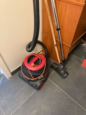 un vide et un aspirateur posés sur le sol d'une pièce