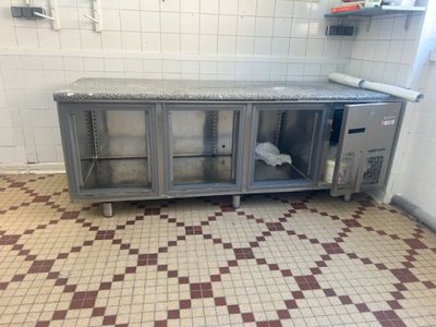 sol carrelé dans une cuisine professionnelle équipée d'armoires en acier inoxydable et d'un sol carrelé