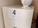a white speaker sitting on top of a shelf next to a tv
