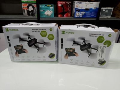 two boxes of remote controlled drones sitting on a table in a store
