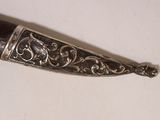 a silver and black object on a white surface