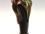 a bronze statue of a frog on a cane