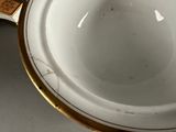 a close up of a white and gold cup on a table