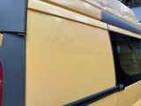 a yellow van with a surfboard on top of it