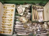 une boîte verte remplie d'argenterie et de cuillères en argent