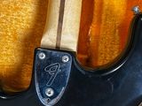 a close up of a guitar with a black body