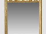 a gold and white mirror sitting on top of a wooden shelf