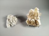 two pieces of white and brown crystals sitting on top of a table