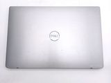 dell laptop computer sitting on a white surface with a dell logo on the screen