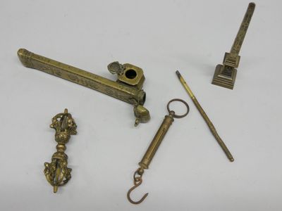 Plusieurs objets en laiton sont exposés sur une surface blanche