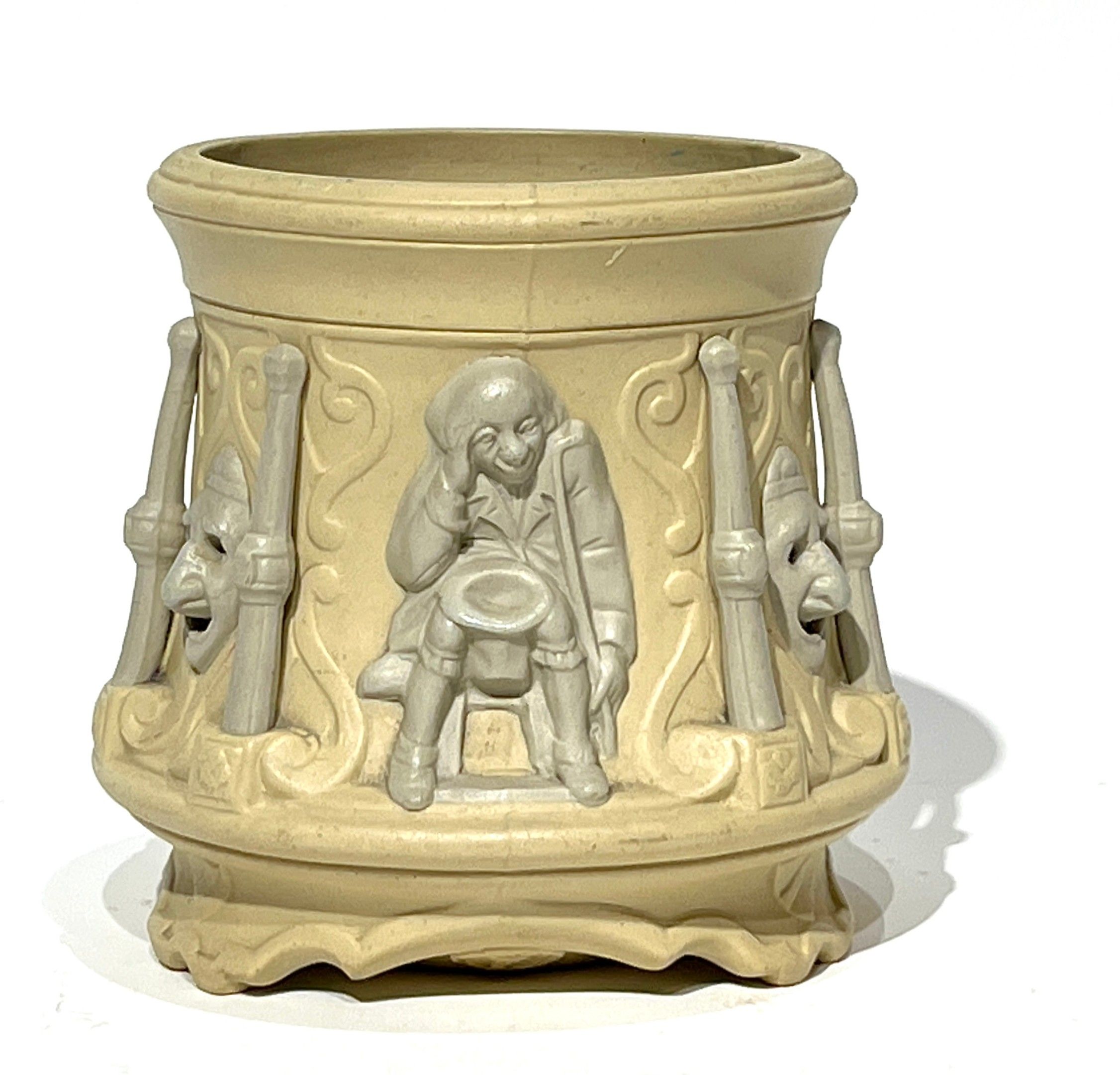 SARREGUEMINES. Pot à tabac en grès fin à décor tournant de masques et personnages. Fin du XIXe siècle. H. 12 cm. Manq...