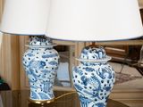 deux vases bleus et blancs posés sur une table avec des lampes