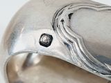 a close up of a silver bracelet with a heart on it
